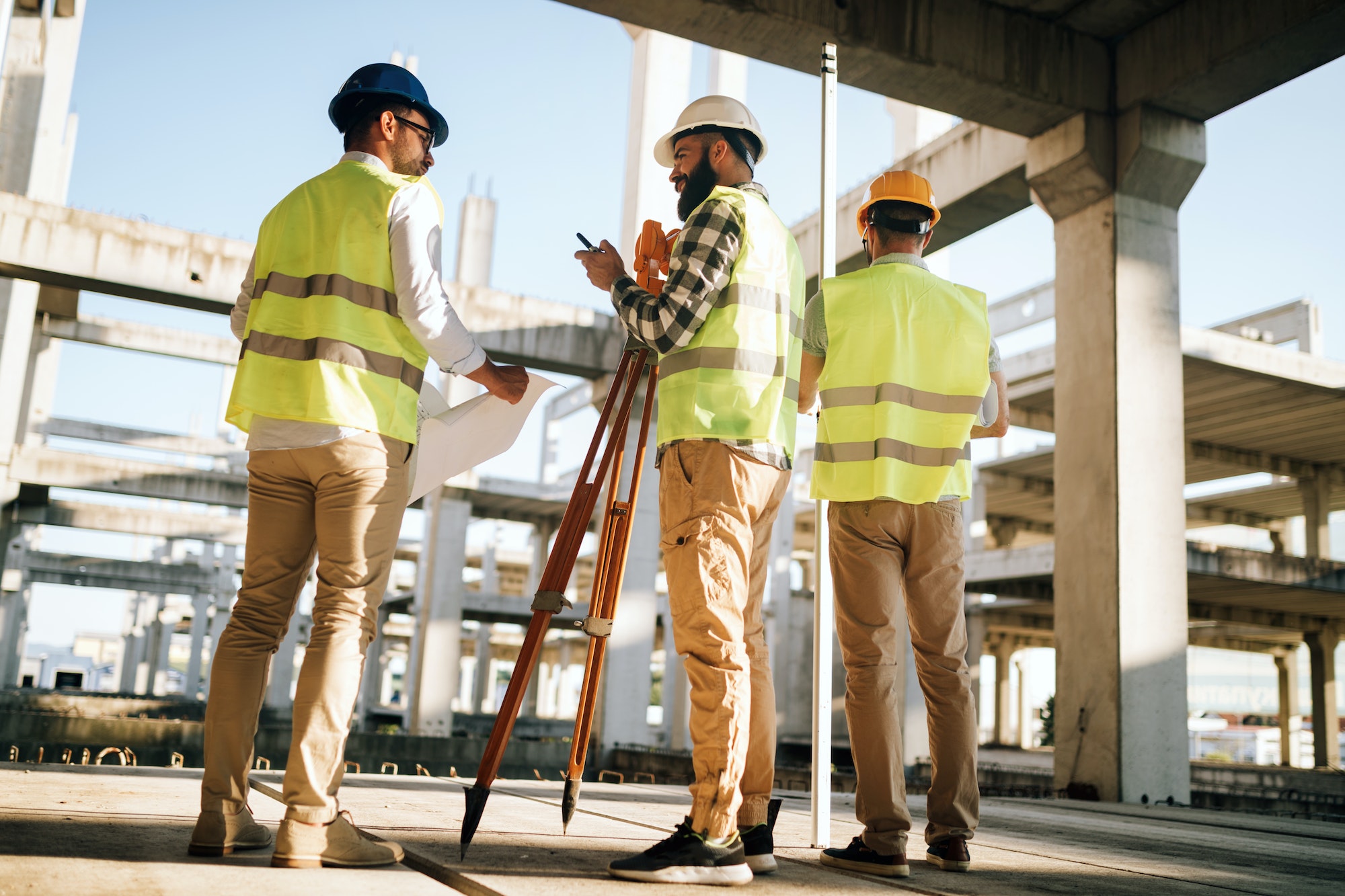 Team of construction engineers working on building site Team of construction engineers working on building site